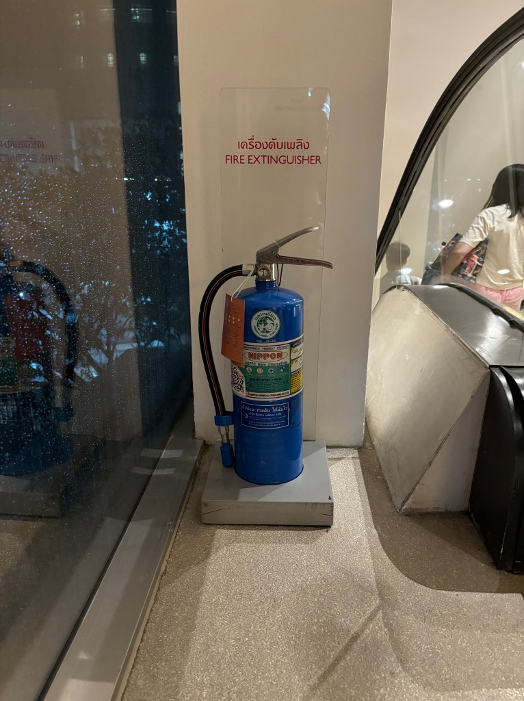 blue extinguisher at the top of an escalator