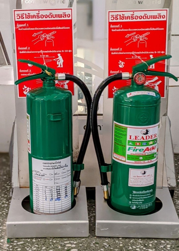 two green fire extinguishers, one displayed on the front and one displayed on the back